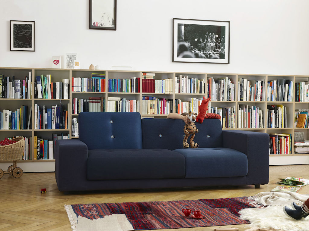 Blaues Polder Sofa von Vitra vor halbhohem Bücherregal