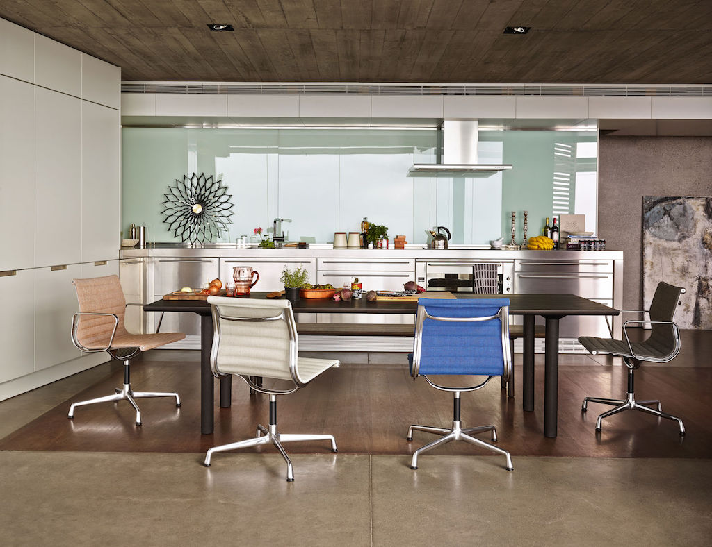 Zukünftige Erbstücke: Vier Eames Aluminium Chair mit Textilbespannung, die um einen großen Esstisch in der Küche stehen