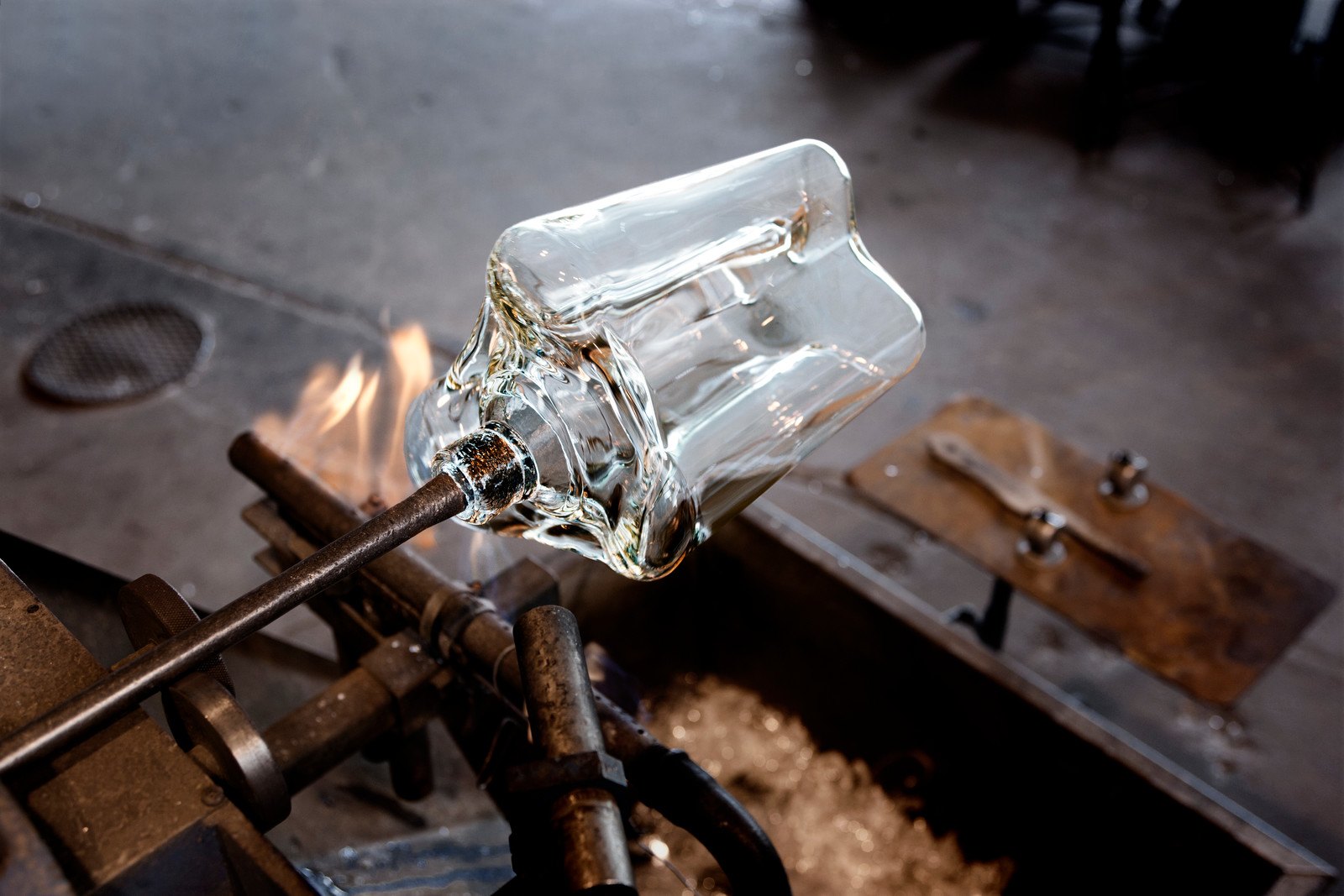 An der Glasmacherpfeife hängt die Vase noch als Hohlglas, bevor sie abgeschnitten wird