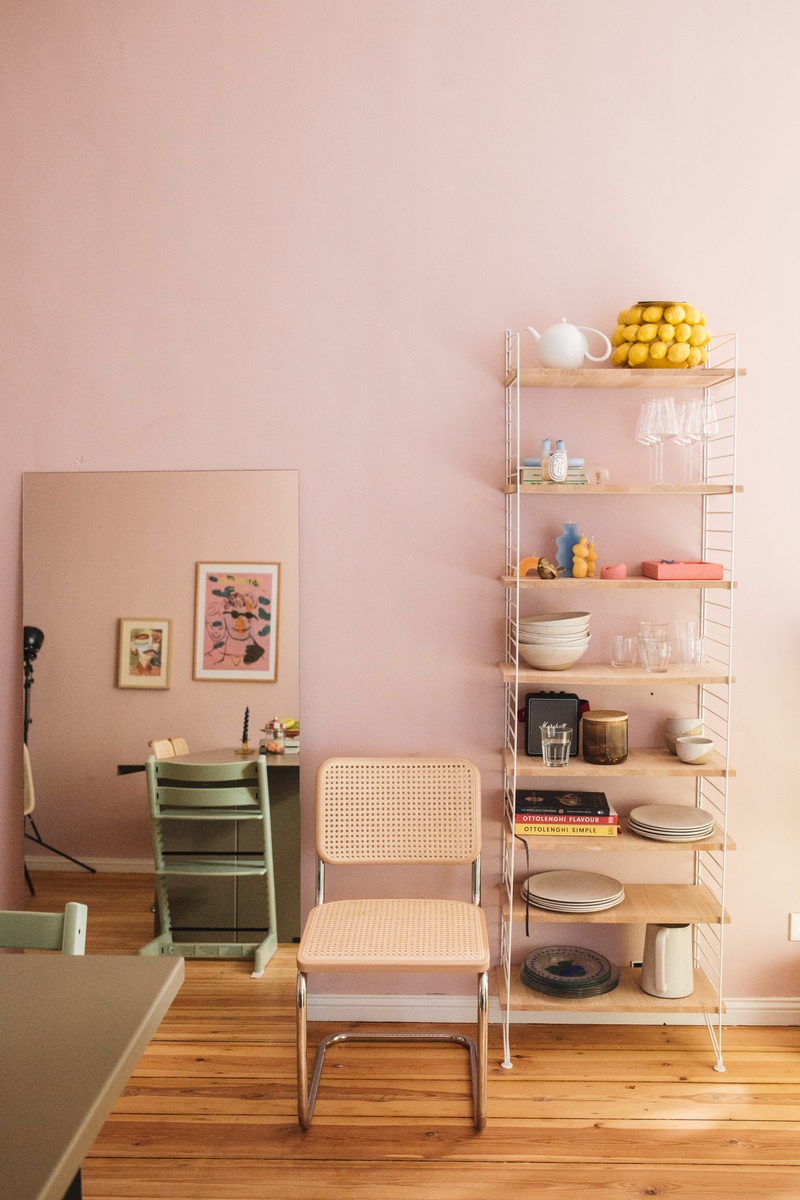 zuhause bei Sarah in ihrer Küche. Zart rosa Wände, Leiterregal und S 64 Stuhl. Im Spiegel an der Wand spiegelt sich der Essplatz.