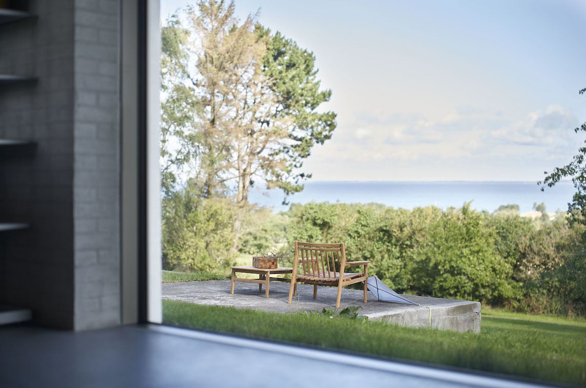 FDB Møbler: 80 Jahre jung. Blick aus dem Panorama-Fenster über den Garten zum Meer. 