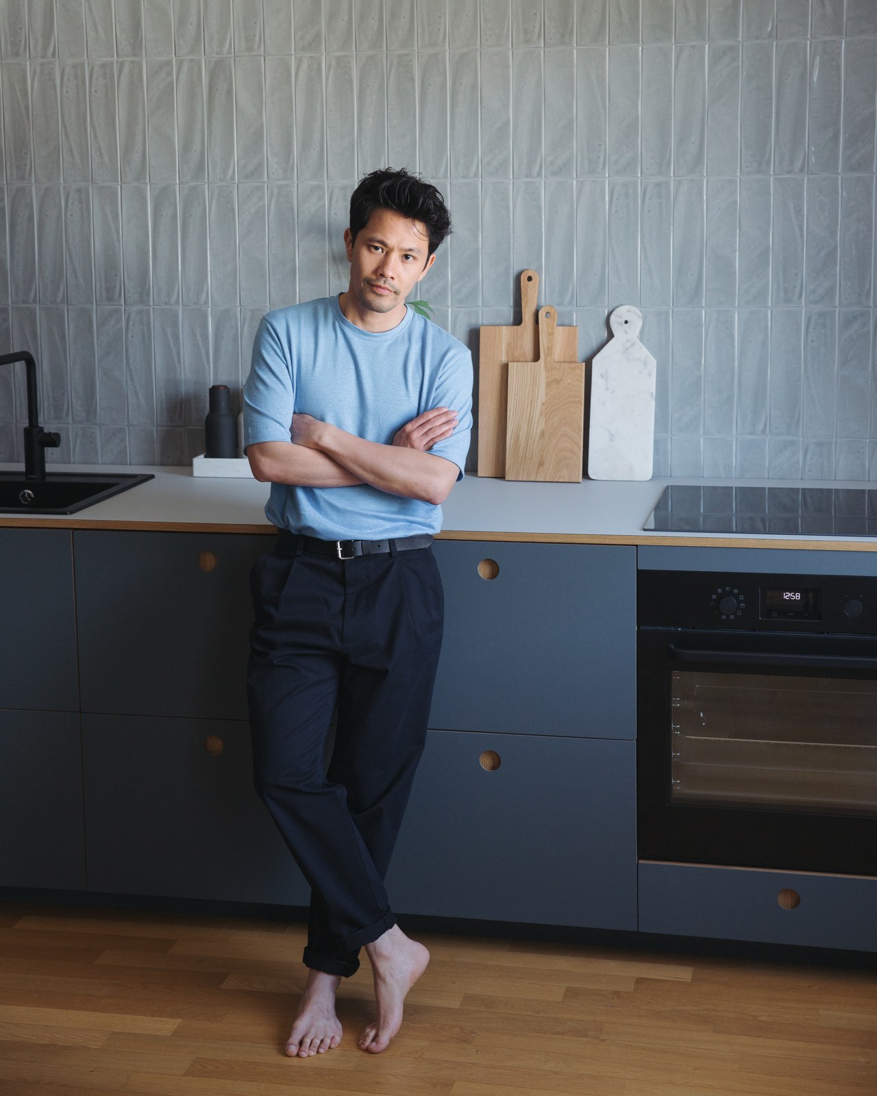 Portrait Linh Tran an seine Küchenzeile gelehnt